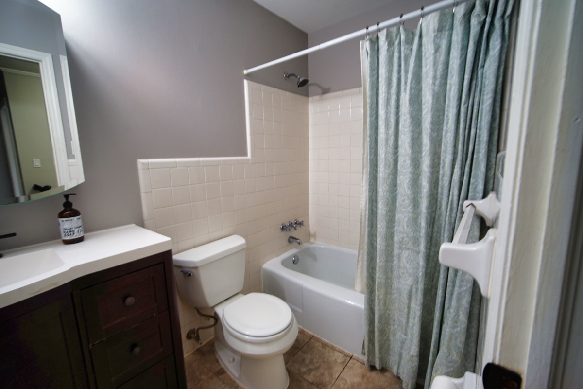 Basement bathroom with vanity, tub-shower combo, and tile floor