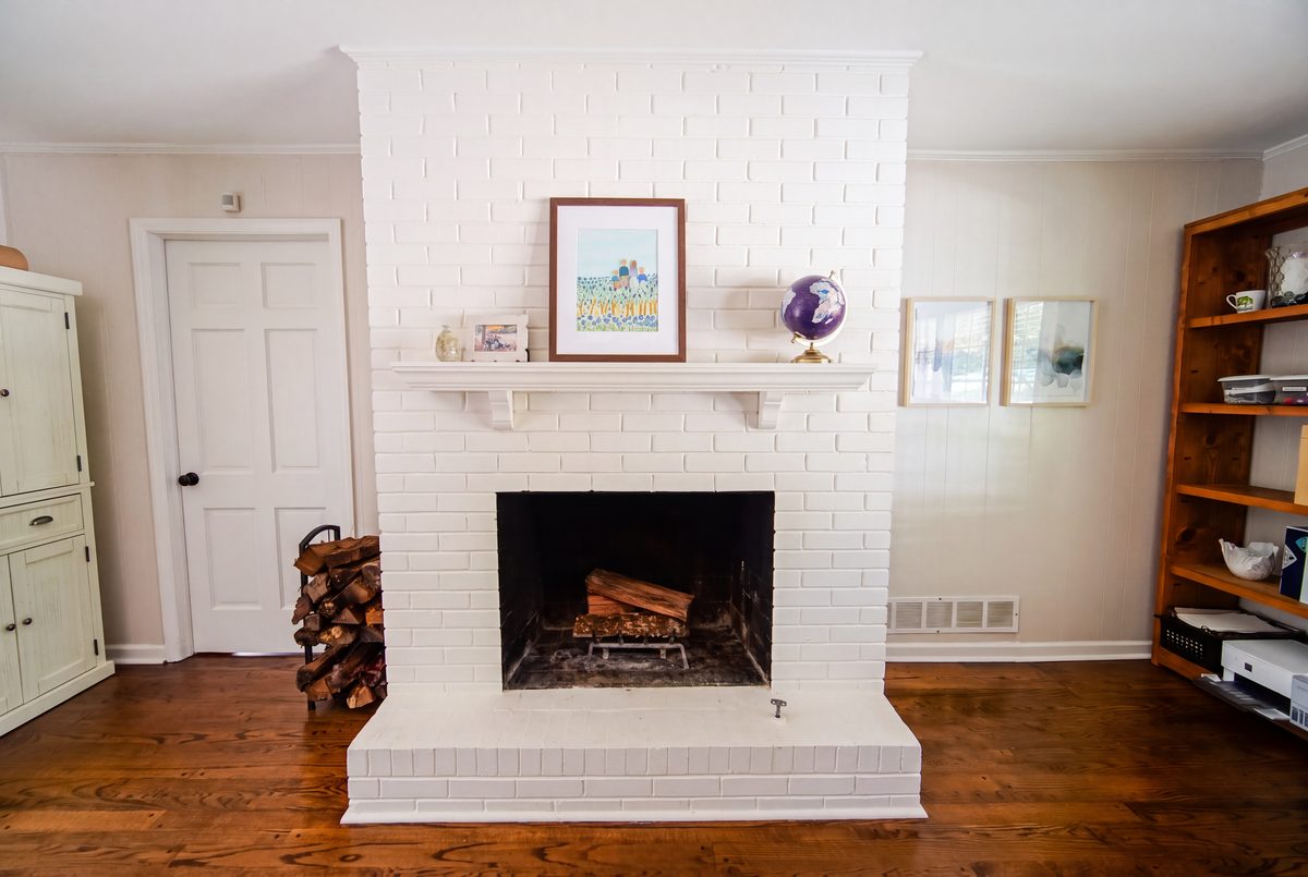 Painted white brick fireplace with mantel in the den