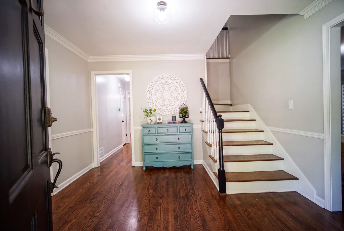 Foyer with front door, hardwood floors, and staircase to the second floor