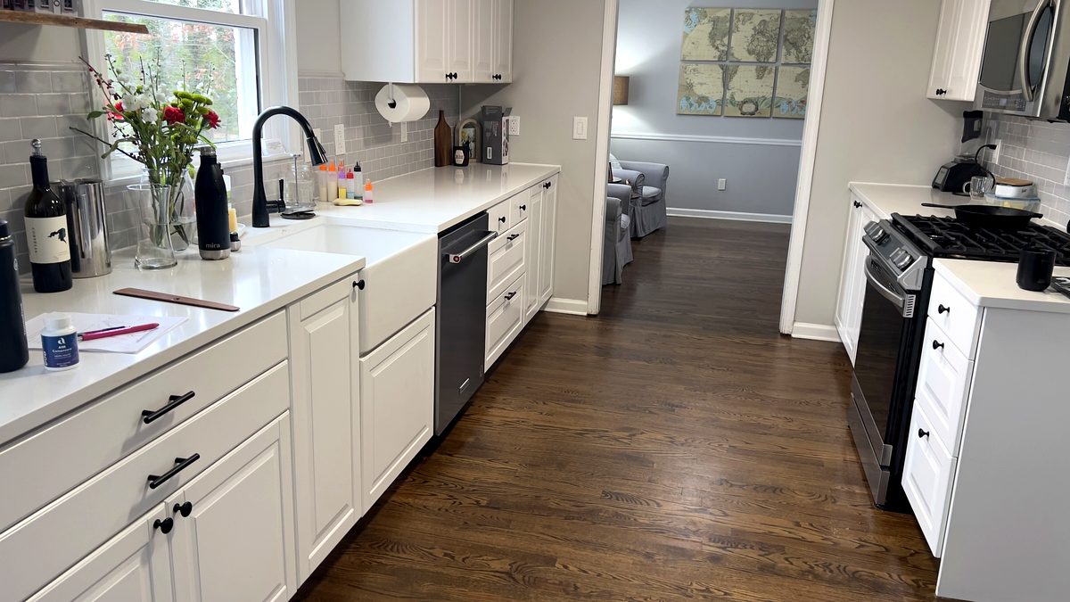 Remodeled kitchen with white cabinets, quartz counters, and hardwood floors