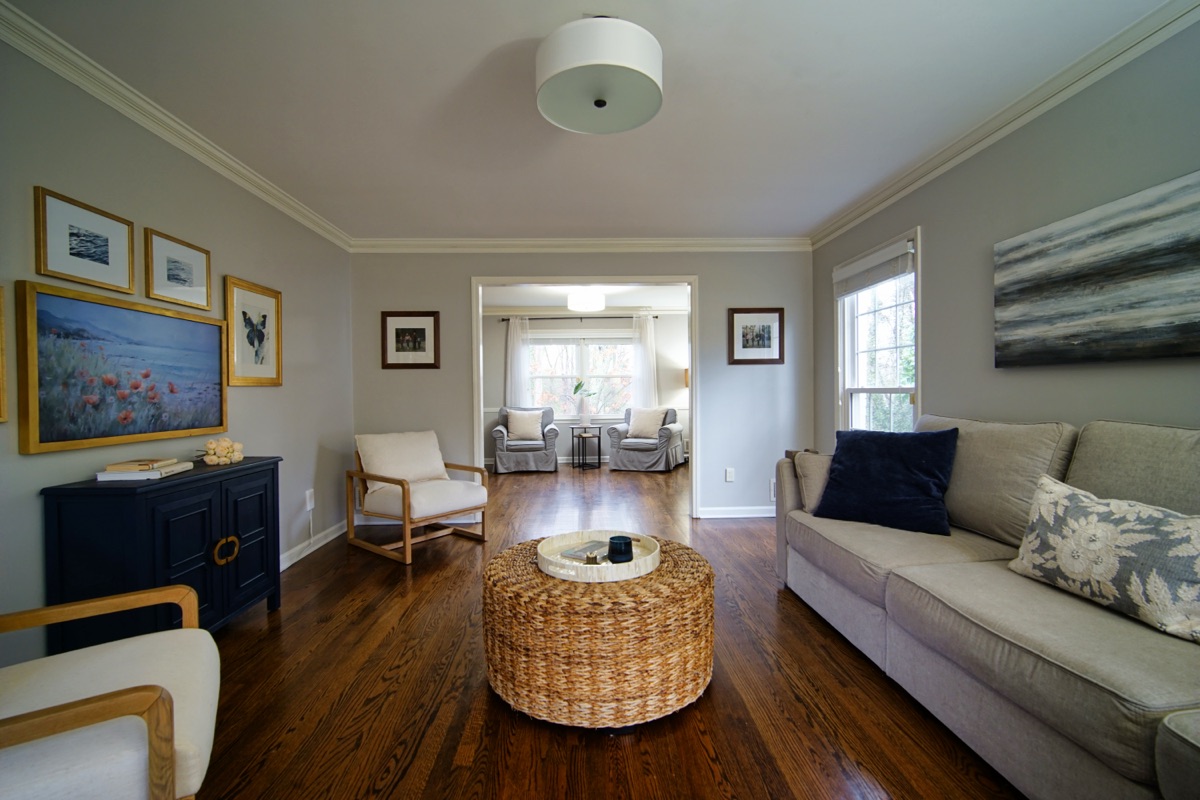 Spacious living room with hardwood floors, crown molding, and natural light